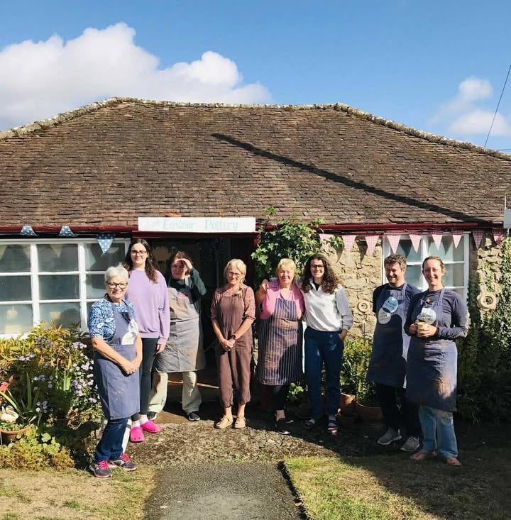 A line of 8 potters stood outside at the front of Eastnor Pottery.