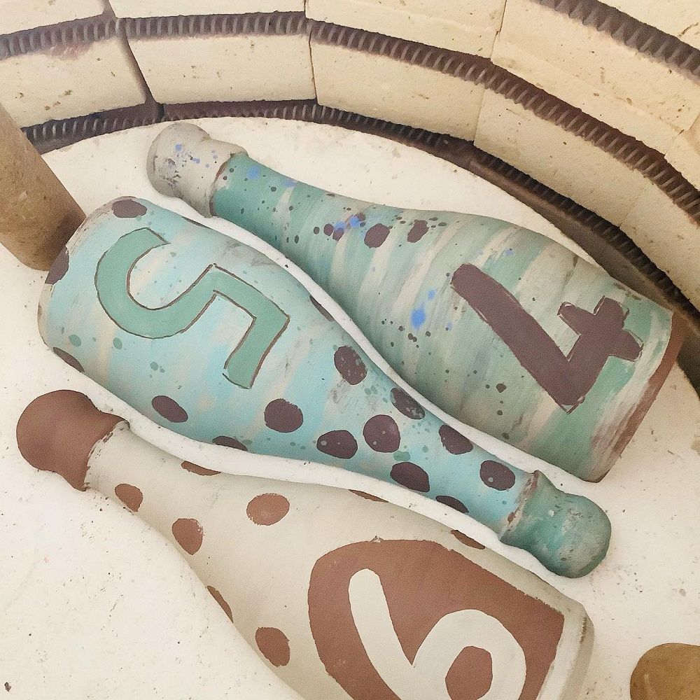 terracotta painted bottles in the kiln before firing with numbers 4, 5 and 6 on them