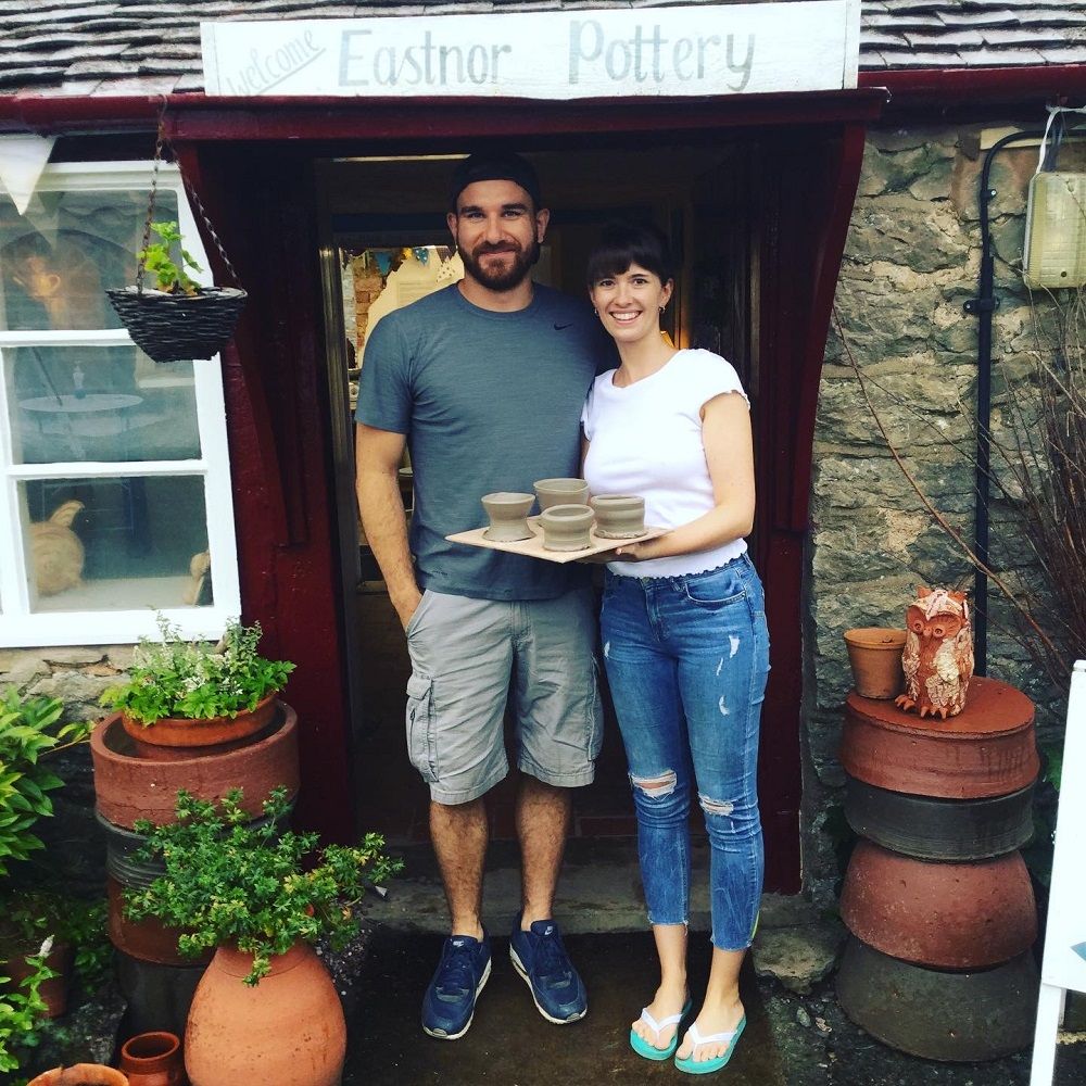 honeymoon couple who took part in a potter's wheel introduction standing outside pottery