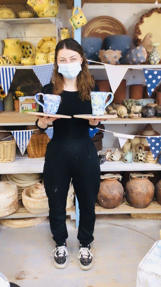 lady holding mugs made on weekend pottery course in the pottery studio