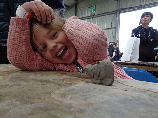 child pleased with her clay unicorn at countrytastic