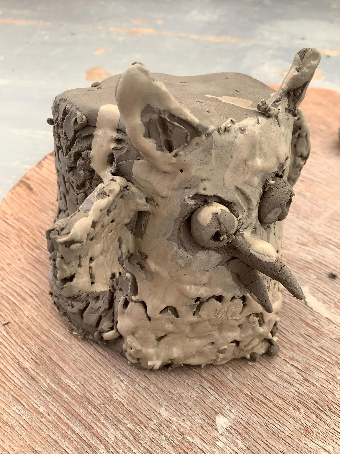 a clay owl made by a child and painted in white slip