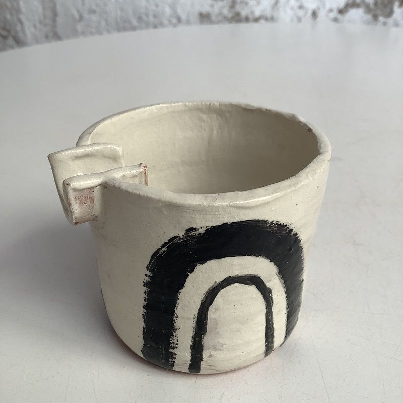 white pot with abstract black rainbow style design made on pottery course at eastnor pottery