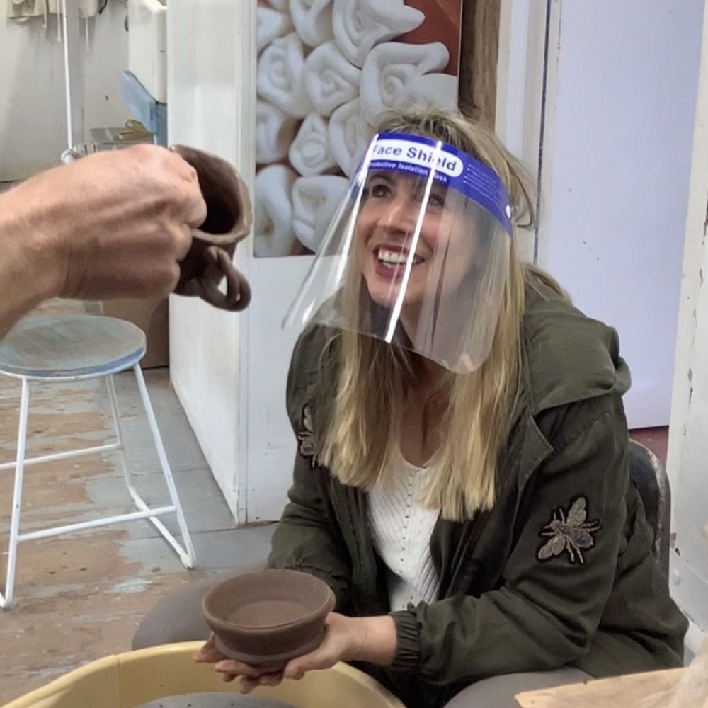 lady smiling at the pots she created on weekend pottery course