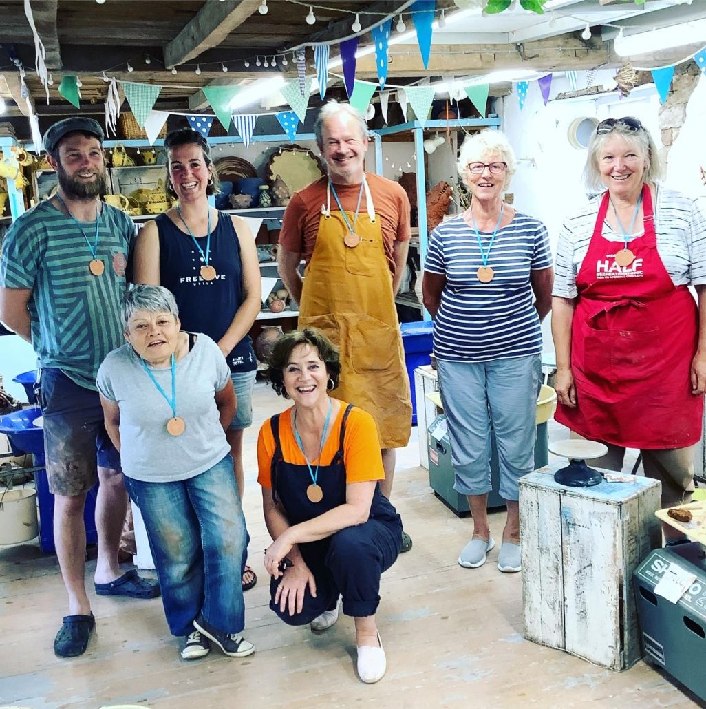 7 pottery students pose for a group photo having just completed a weekend potter's wheel course