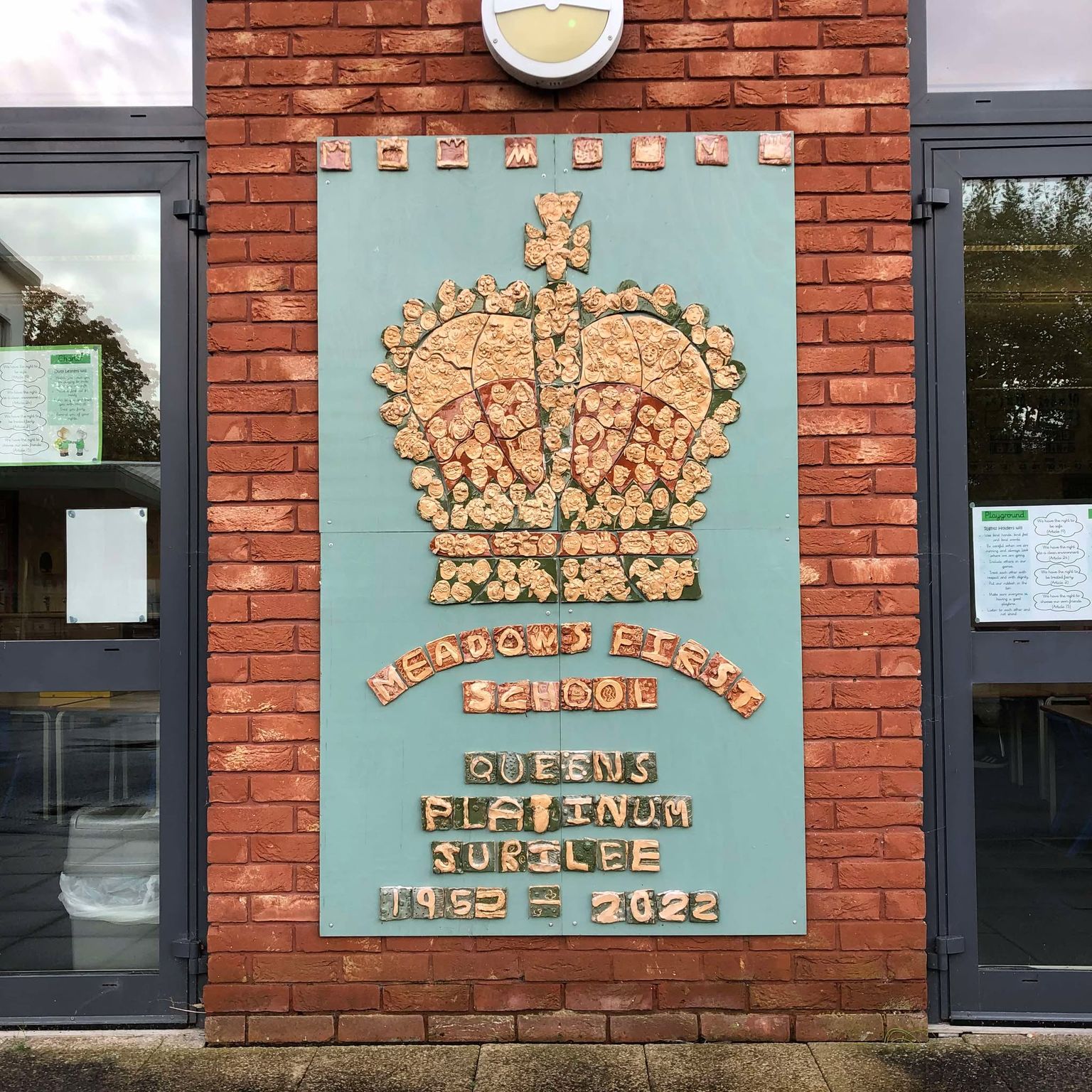 a mosaic of clay tiles made by first school aged children from meadows first school in bromsgrove in the shape of a crown to commemorate queen elizabeth's platinum jubilee