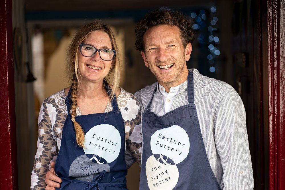 eastnor pottery founders and artists sarah monk and jon williams outside the open front door of the studio
