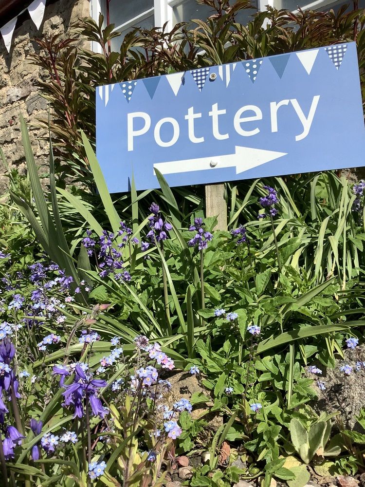 pottery sign and bluebells at eastnor pottery herefordshire