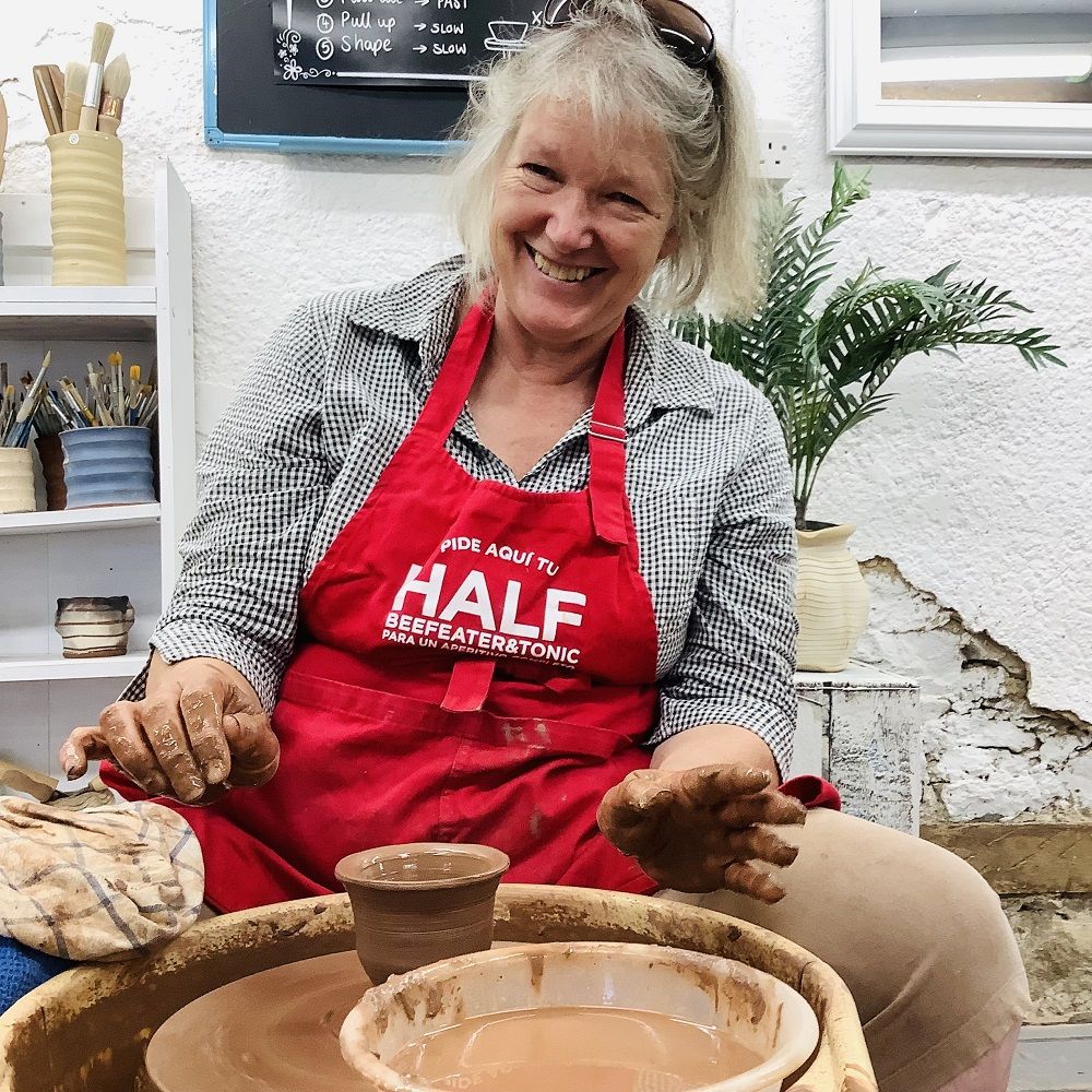 lady on the potter's wheel at eastnor pottery participating on a pottery course