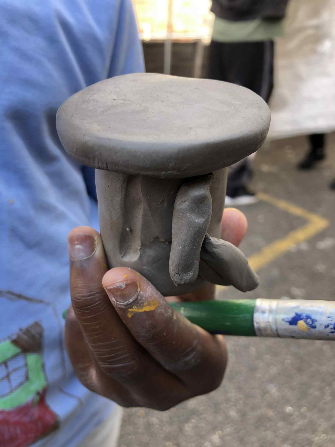 close up of a clay model of a potter's wheel held in a child's hand It was made by a child on a community art project in cambridge facilitated by jon williams the flying potter from eastnor pottery