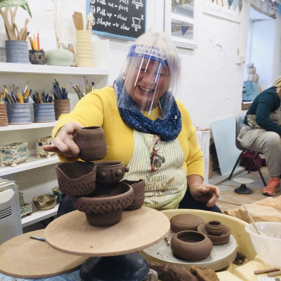 lady participating in pottery weekend course placing her pots in display