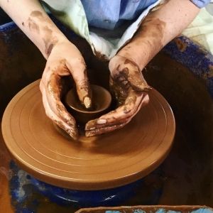 pottery course participant at eastnor pottery cupping a spinning clay pot