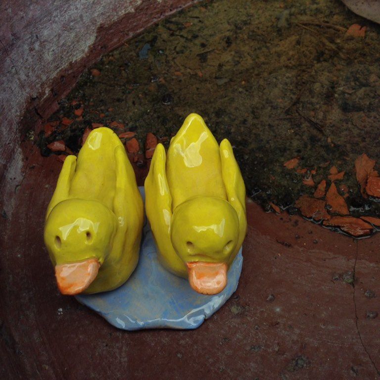 two bright yellow pottery ducks made by a customer at eastnor pottery