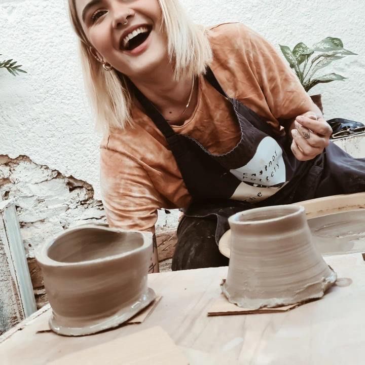 young woman laughing and enjoying a pottery class at eastnor pottery