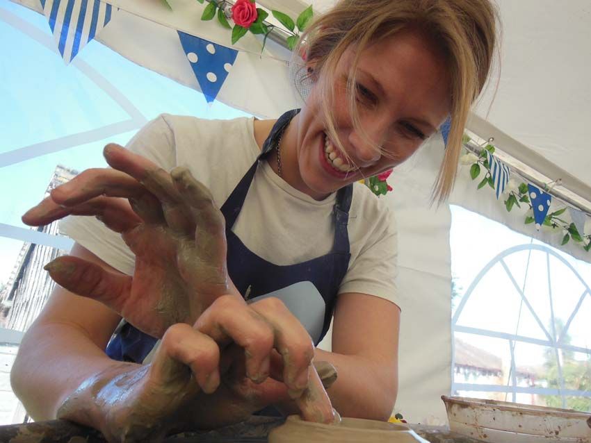 girl laughing making a pot on the potter's wheel at friends pottery hen party