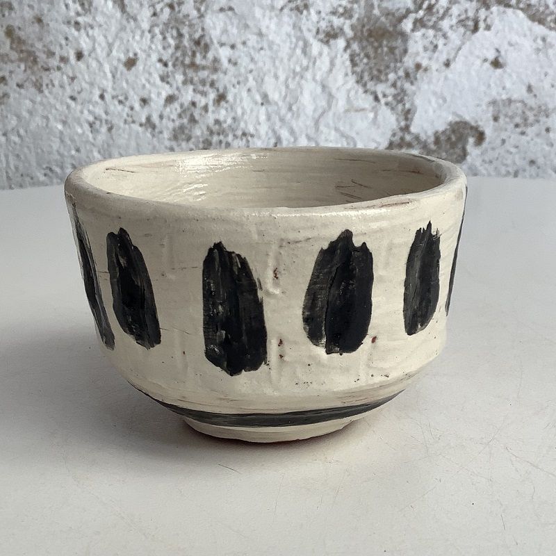 white bowl with bold black brush marks made on pottery course at eastnor pottery