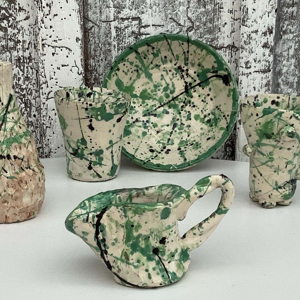 selection of pots and plates painted white and splattered with shades of green and blue