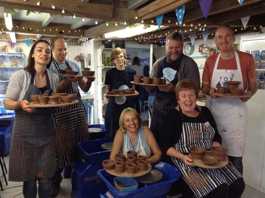 Group of pottery making participants on a potter's wheel workshop in Herefordshire