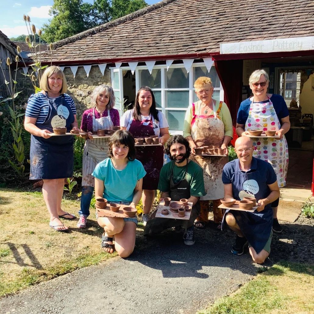 group of 8 pottery course participants standing outside eastnor pottery in the summer sunshine