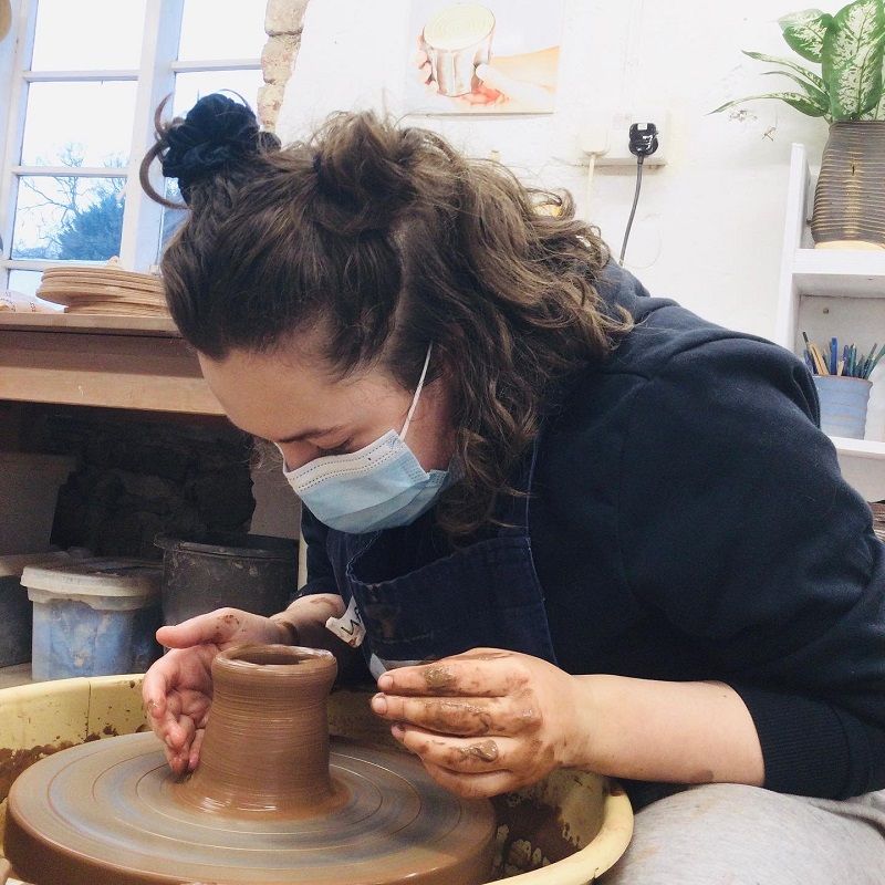 pottery course partcipant staring into the bottom of her pot