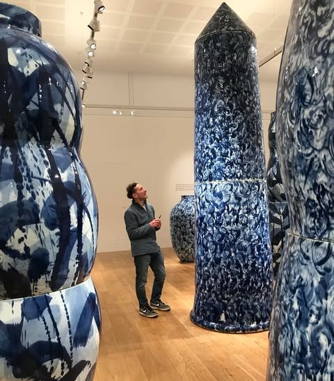 Jon Williams standing amongst Felicity Ayleiffs gigantic porcelein pots at Kew Gardens inside the Shirley Sherwood Gallery.