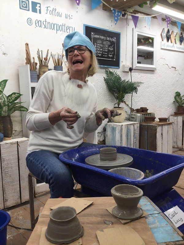 hen party participant sat at the potter's wheel in stitches of laughter