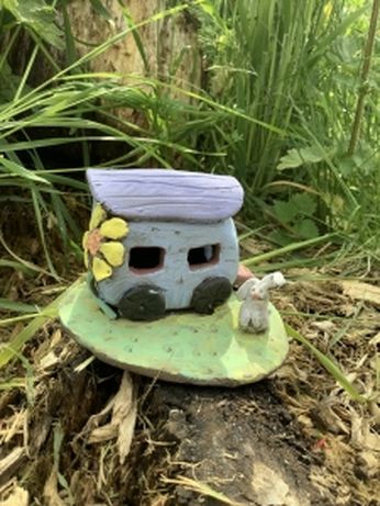 purple camper van with a yellow flower on the side, with a green base and white rabbit, hand modeled with clay