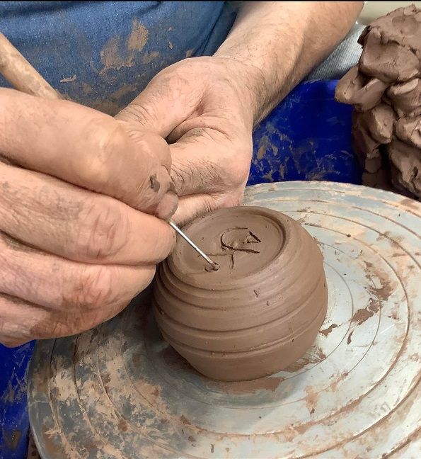 course participant signing their pots at eastnor pottery