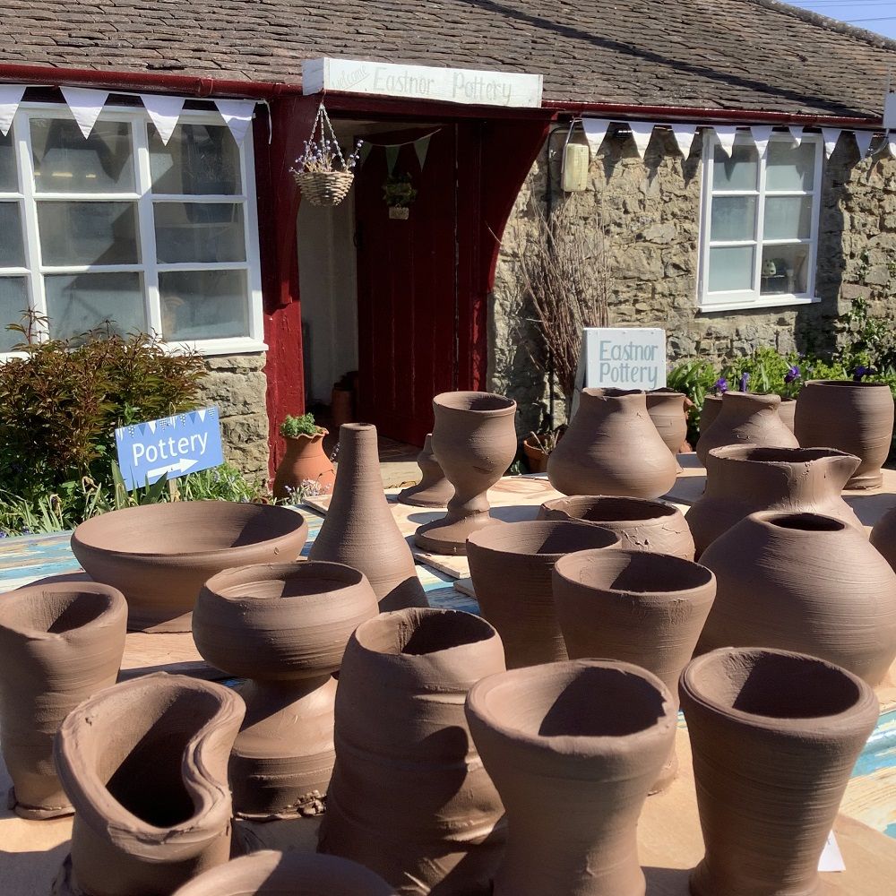 potter's wheel course participants work drying in the sun at eastnor pottery