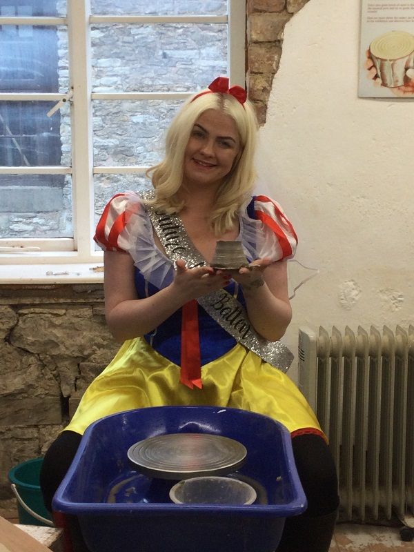 snow white proudly displays her clay pot made on the potter's wheel at eastnor pottery