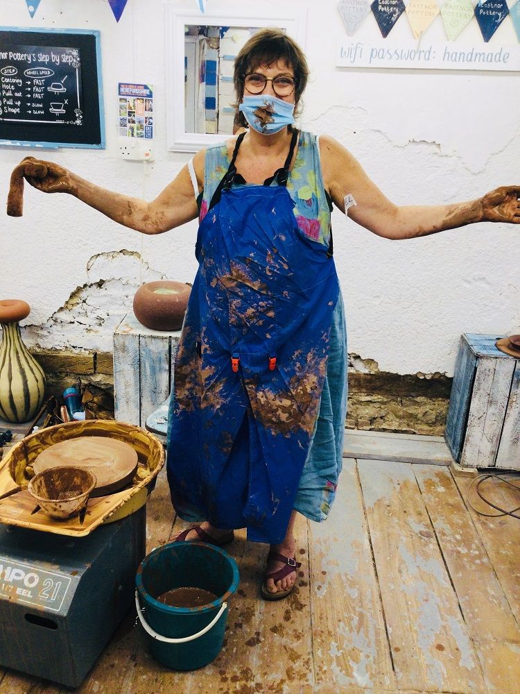 pottery course student covered in terracotta clay