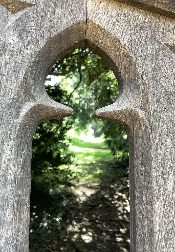 wooden castle gate with a woodland path behind