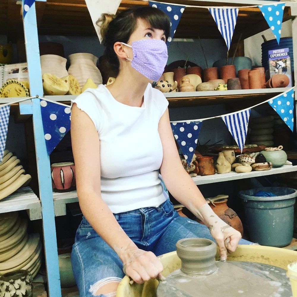 Lady wiring off her pot from the wheel thrown at a potter's wheel introduction